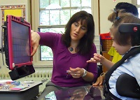 photo of PRC consultant working with young girl using eye gaze