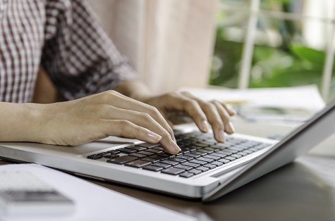 photo of hands on a laptop keyboard